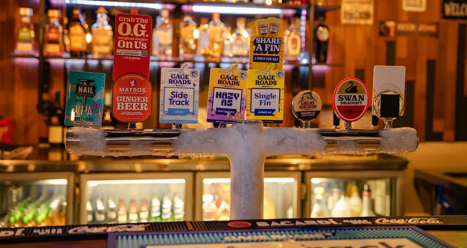The Old Forge beer taps with the warmly lit back bar behind them